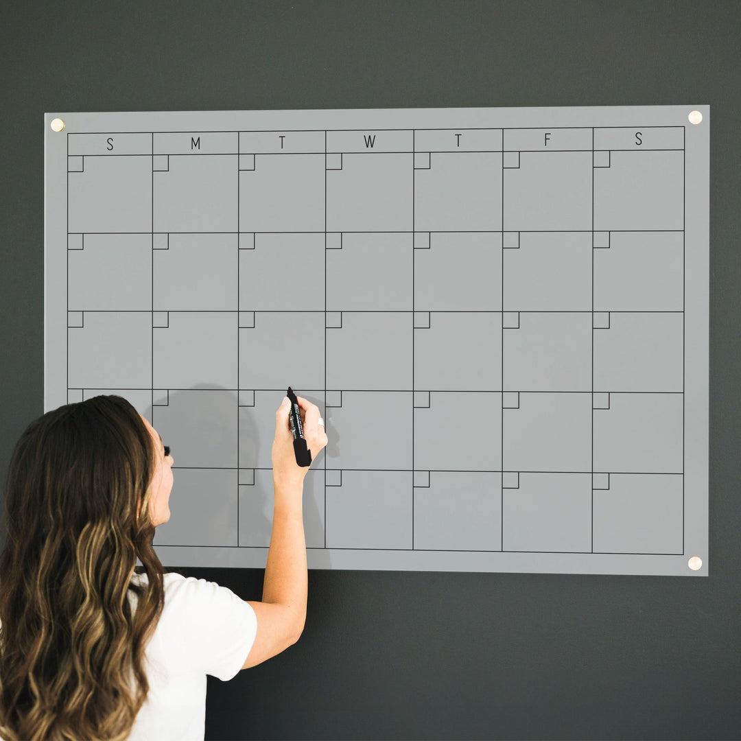 A Dry-erase monthly calender made of acrylic hanging on the wall