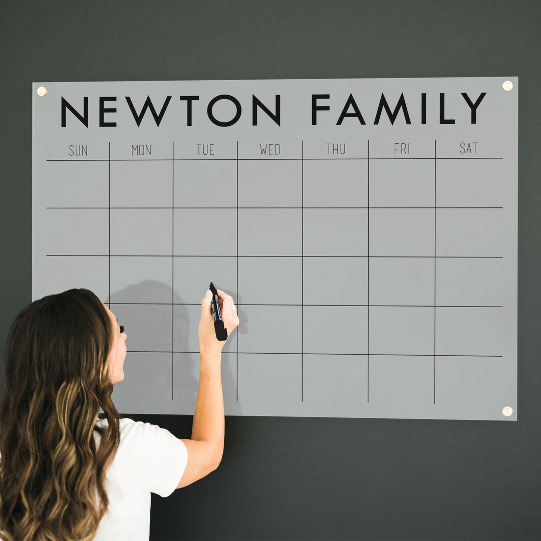 A Dry-erase monthly calender made of acrylic hanging on the wall