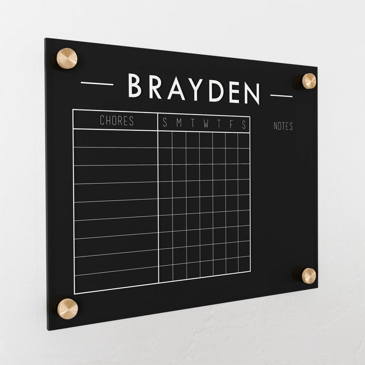 A Dry-erase acrylic chore chart hanging on the wall