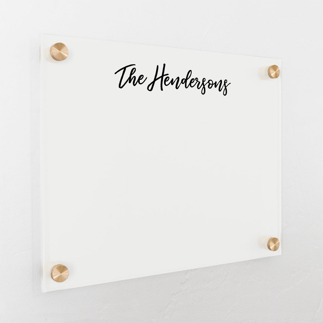 A dry-erase board made of clear acrylic with a custom title up top