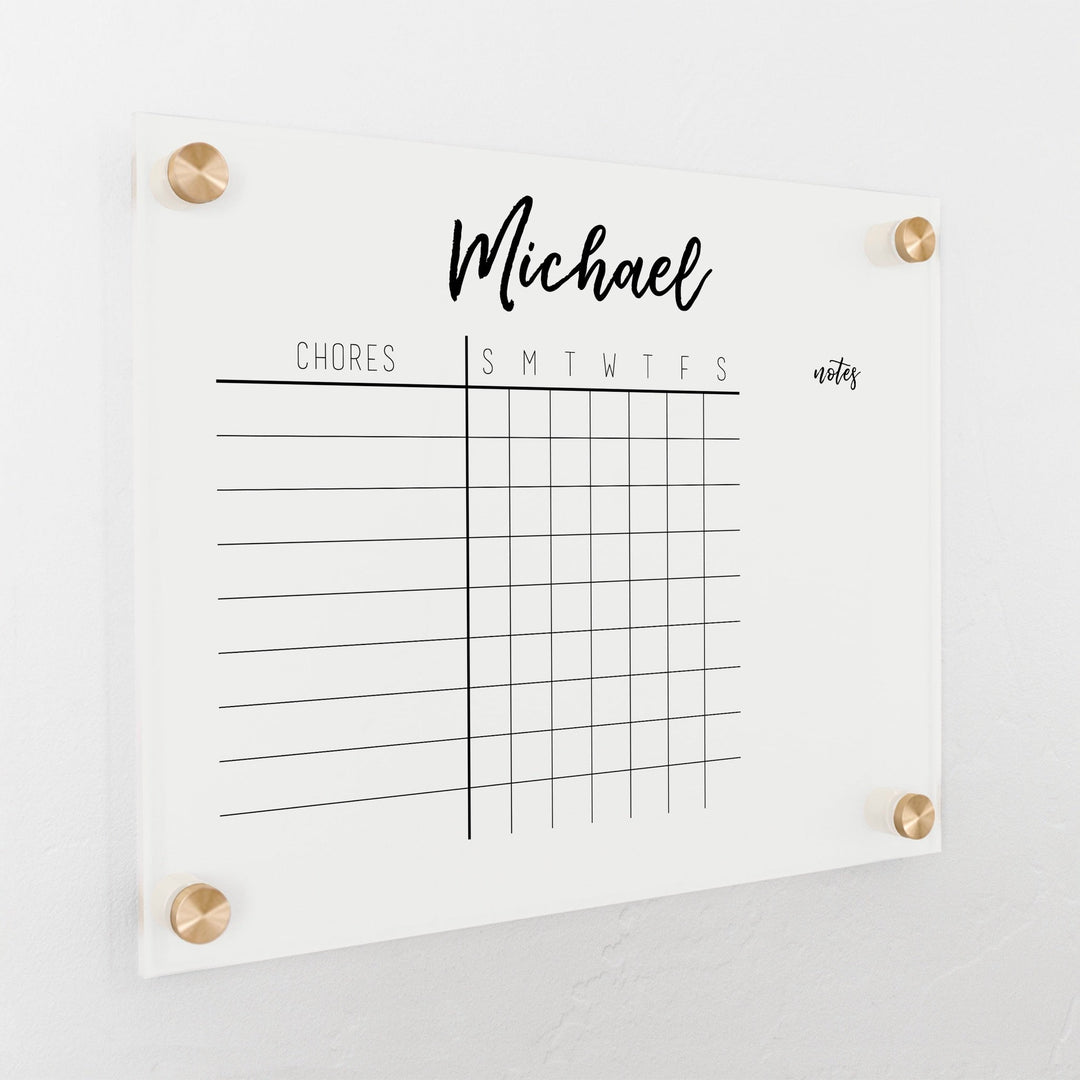 A Dry-erase acrylic chore chart hanging on the wall