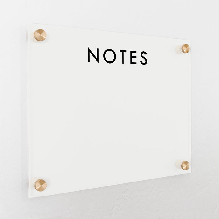 A dry-erase board made of clear acrylic with a custom title up top