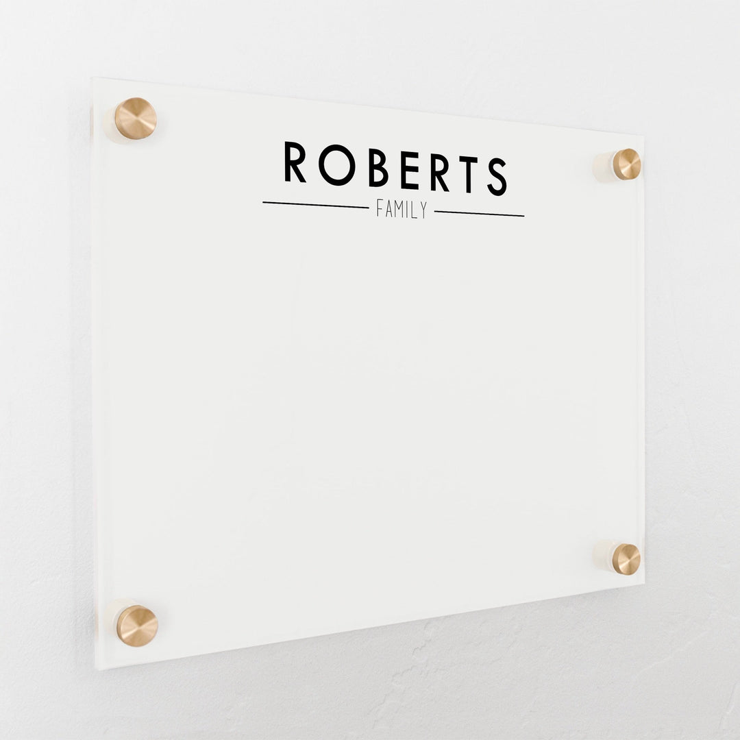 A dry-erase board made of clear acrylic with a custom title up top