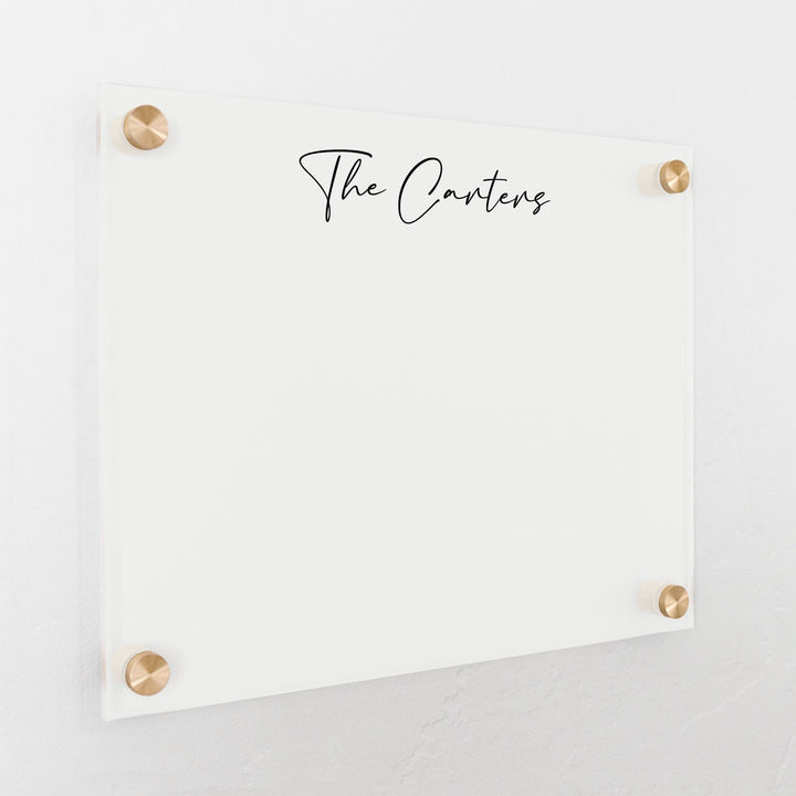 A dry-erase board made of clear acrylic with a custom title up top