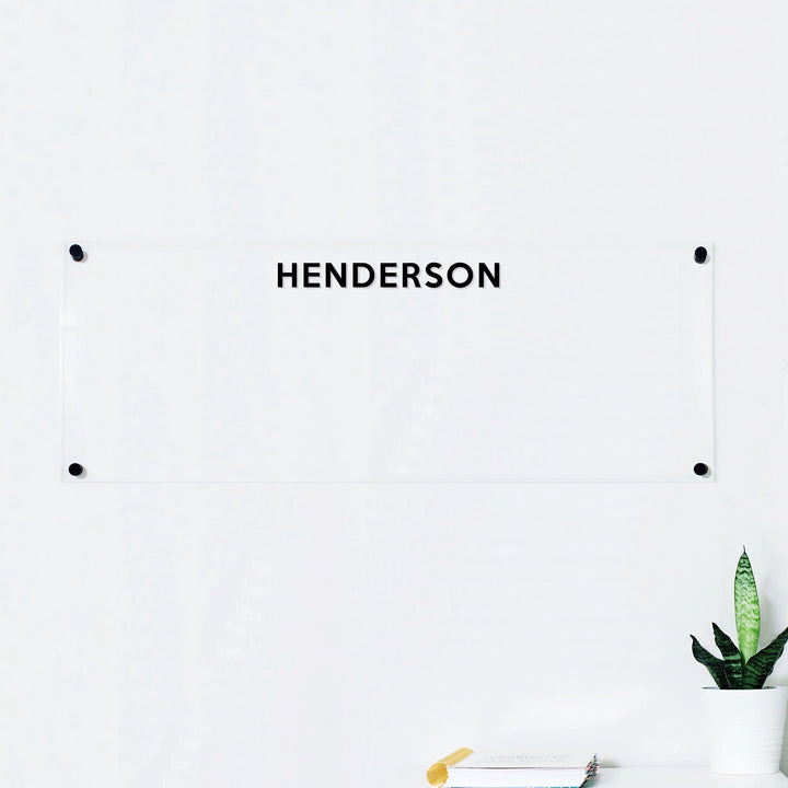 A dry-erase board made of clear acrylic with a custom title up top