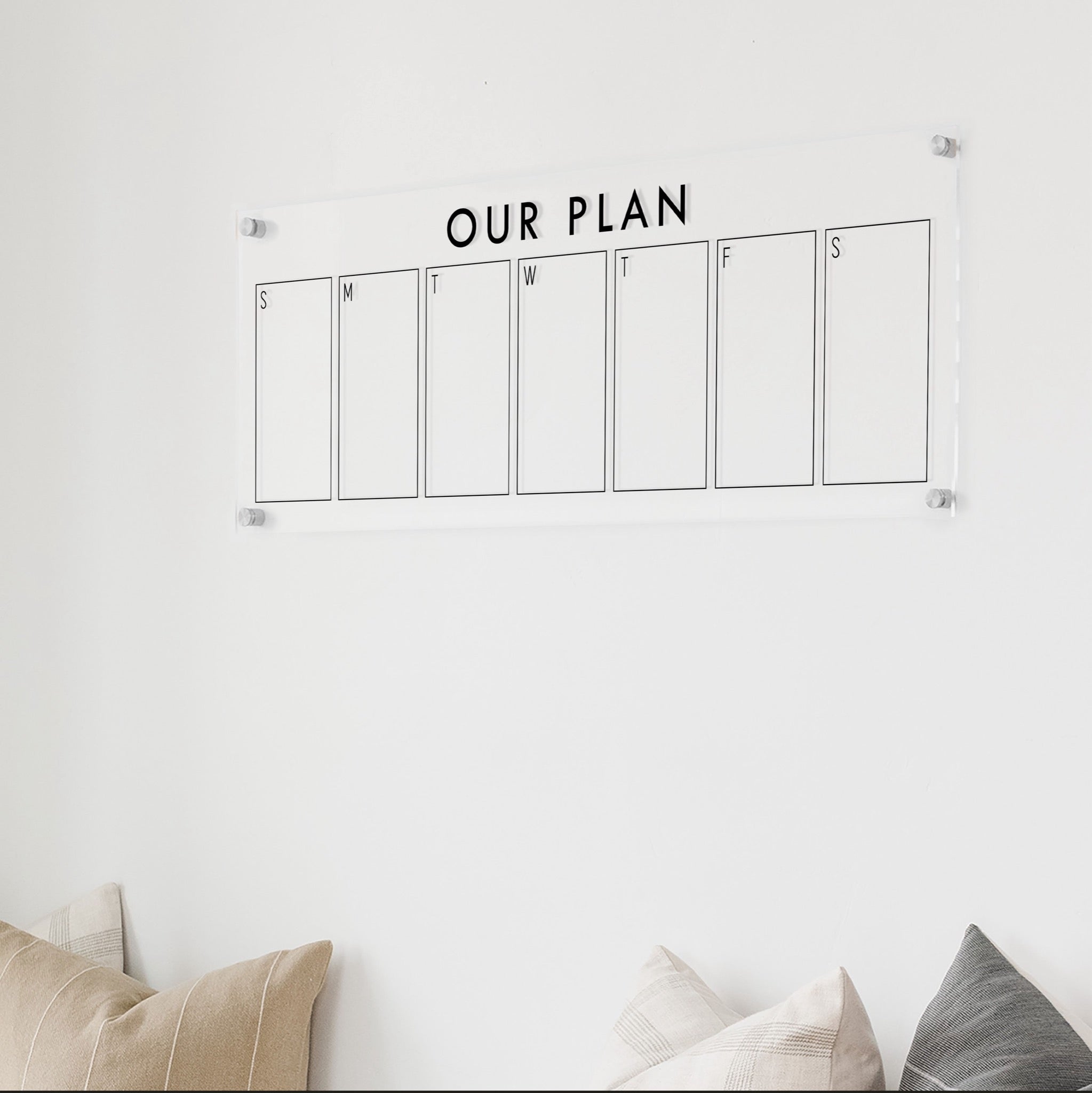 A skinny dry-erase weekly calender made of acrylic hanging on the wall
