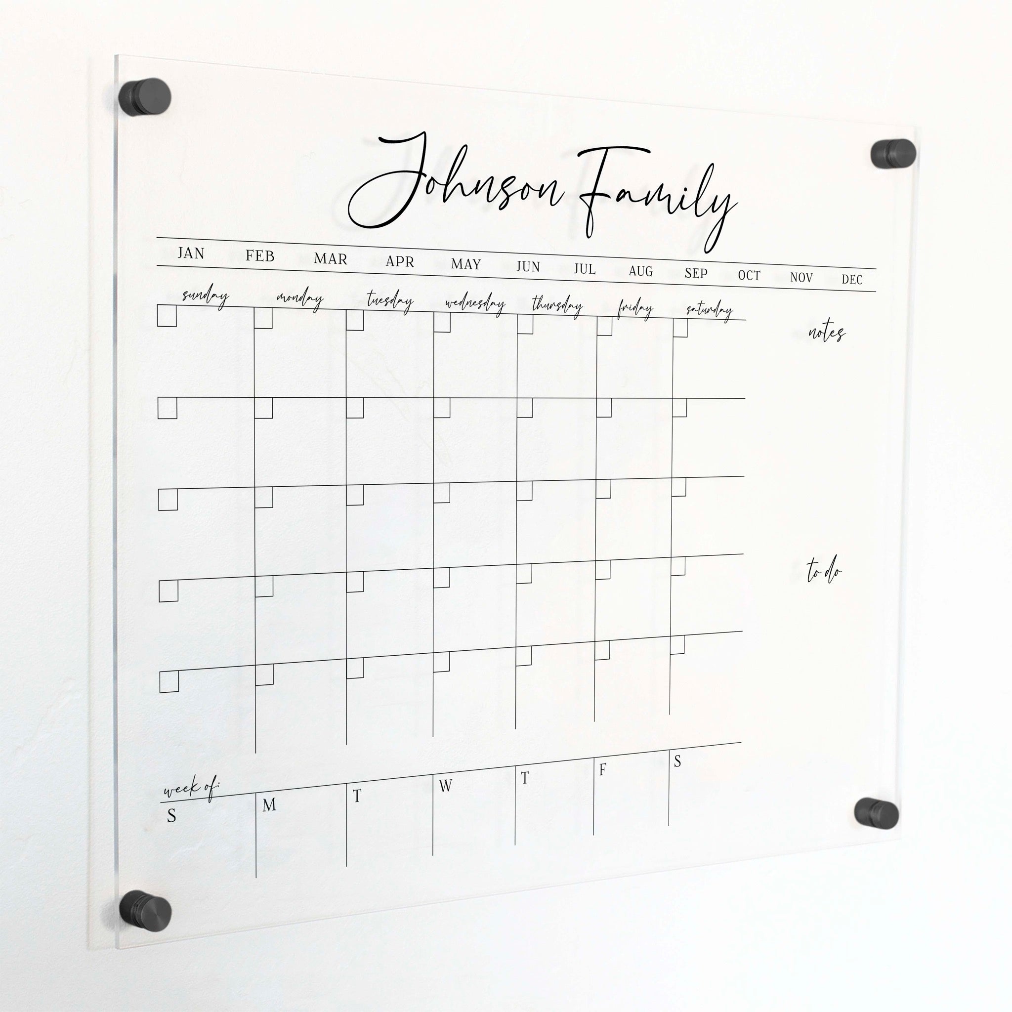 A Dry-erase calendar with a monthly and weekly format made of acrylic hanging on the wall