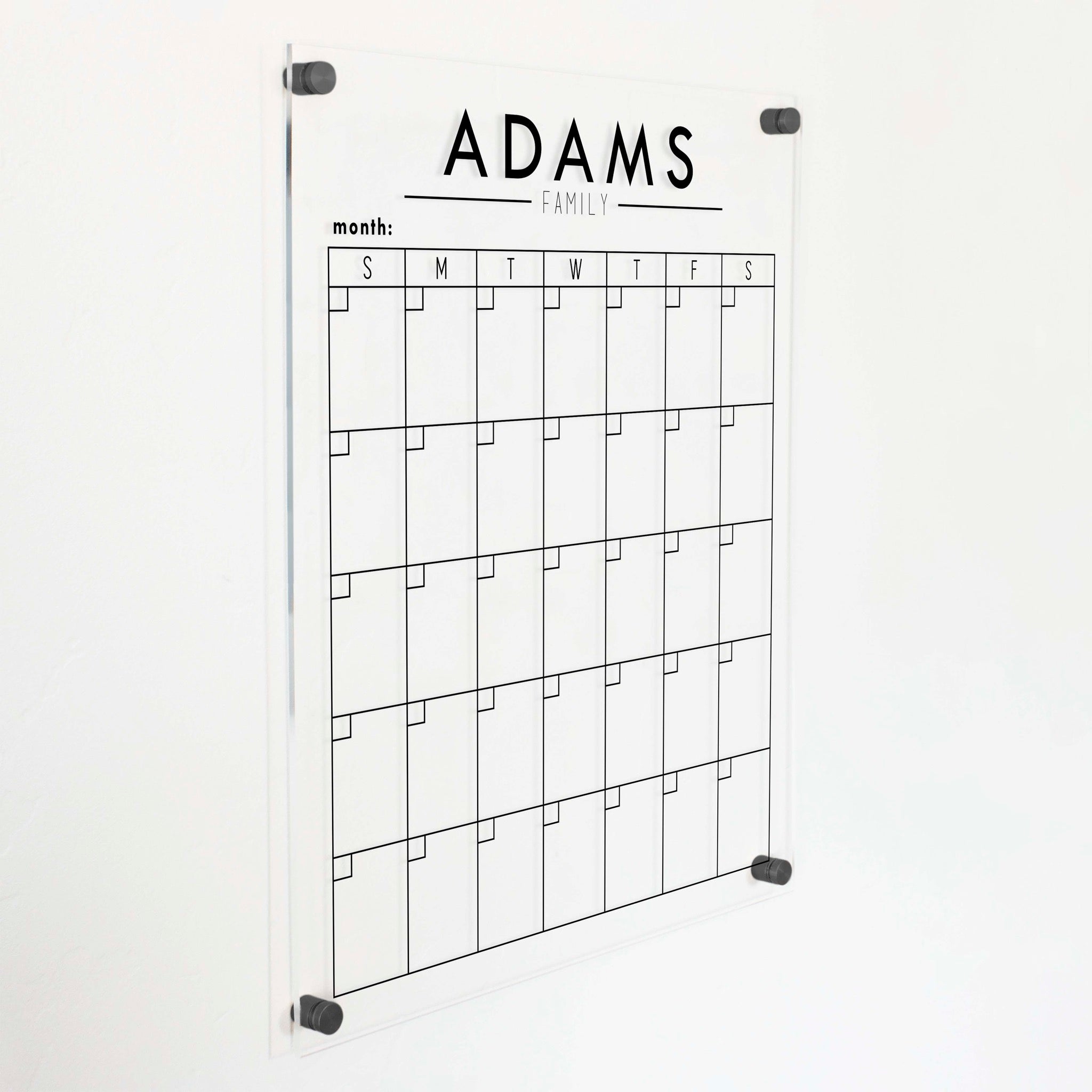 A Dry-erase monthly calender made of acrylic hanging on the wall
