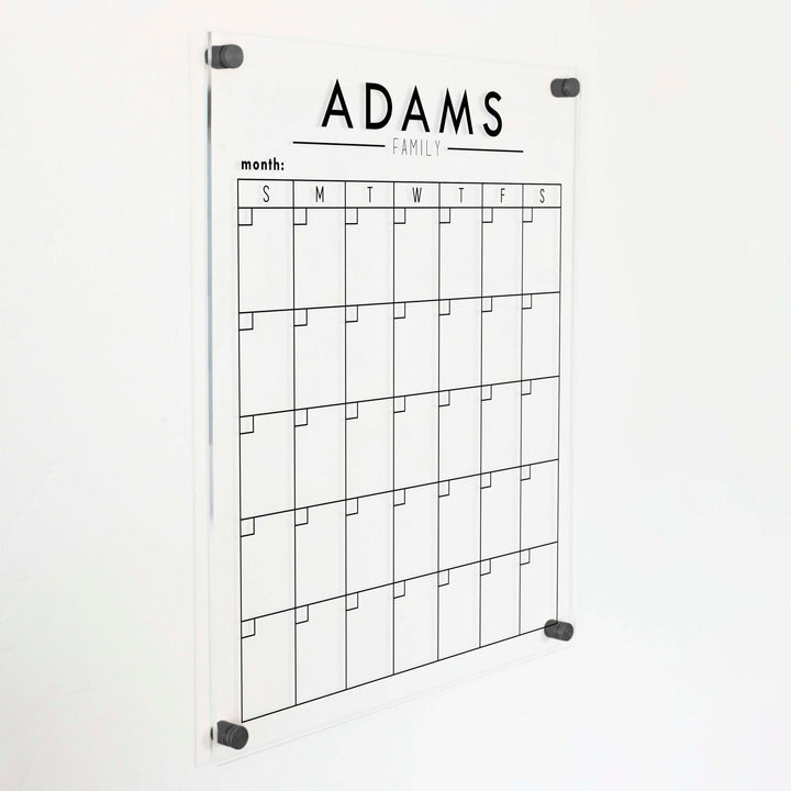 A Dry-erase monthly calender made of acrylic hanging on the wall