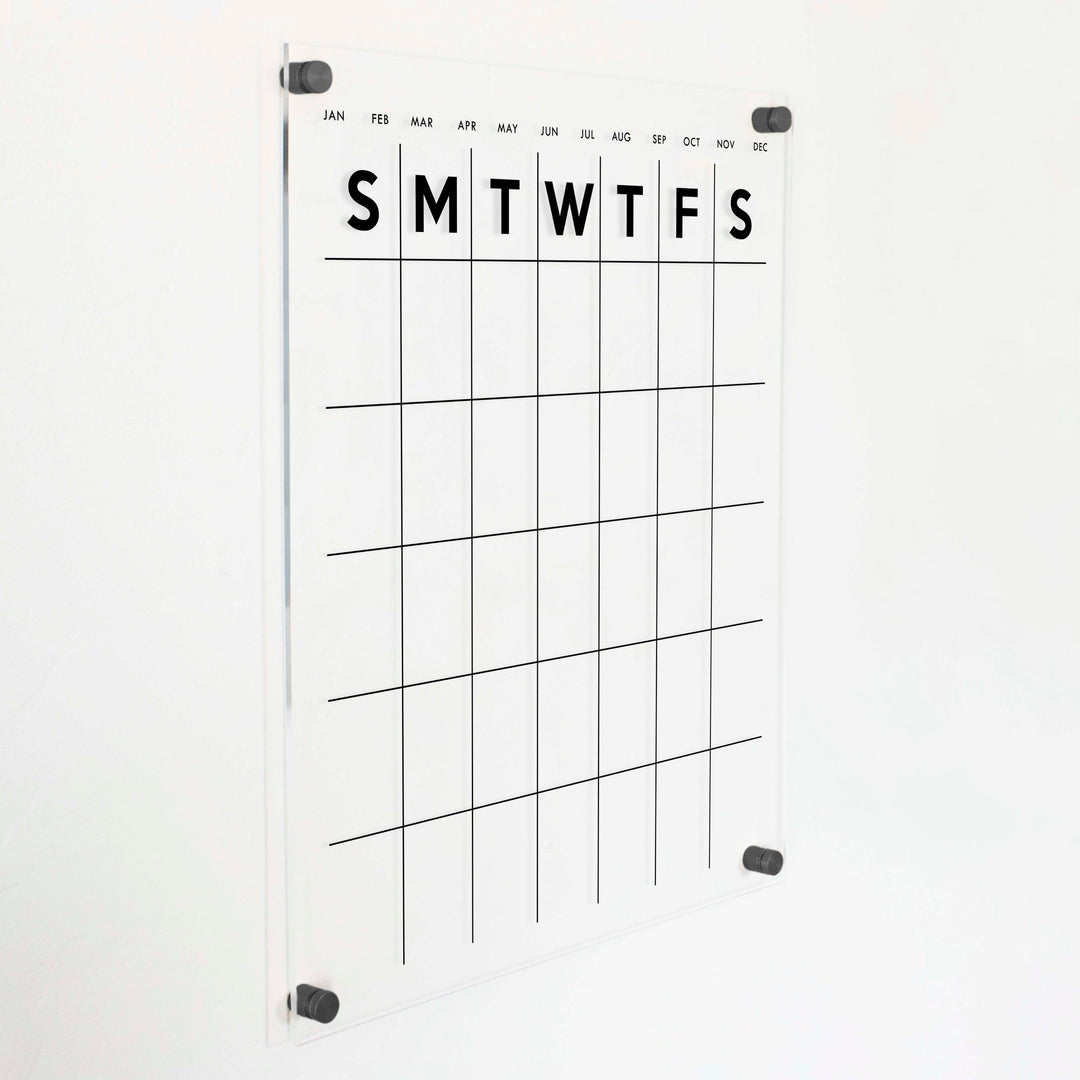 A Dry-erase monthly calender made of acrylic hanging on the wall