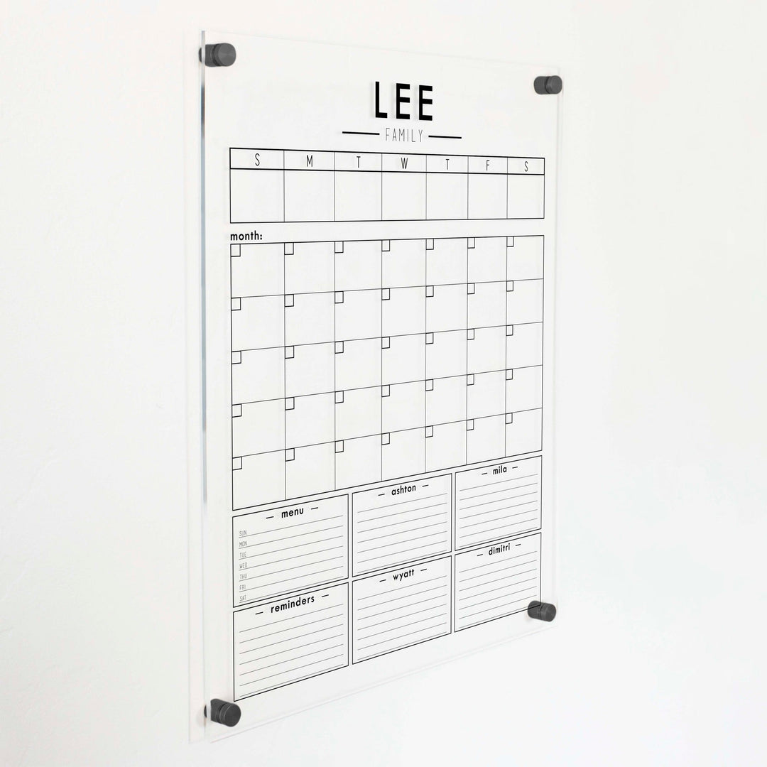 A Dry-erase calendar with a monthly and weekly format made of acrylic hanging on the wall