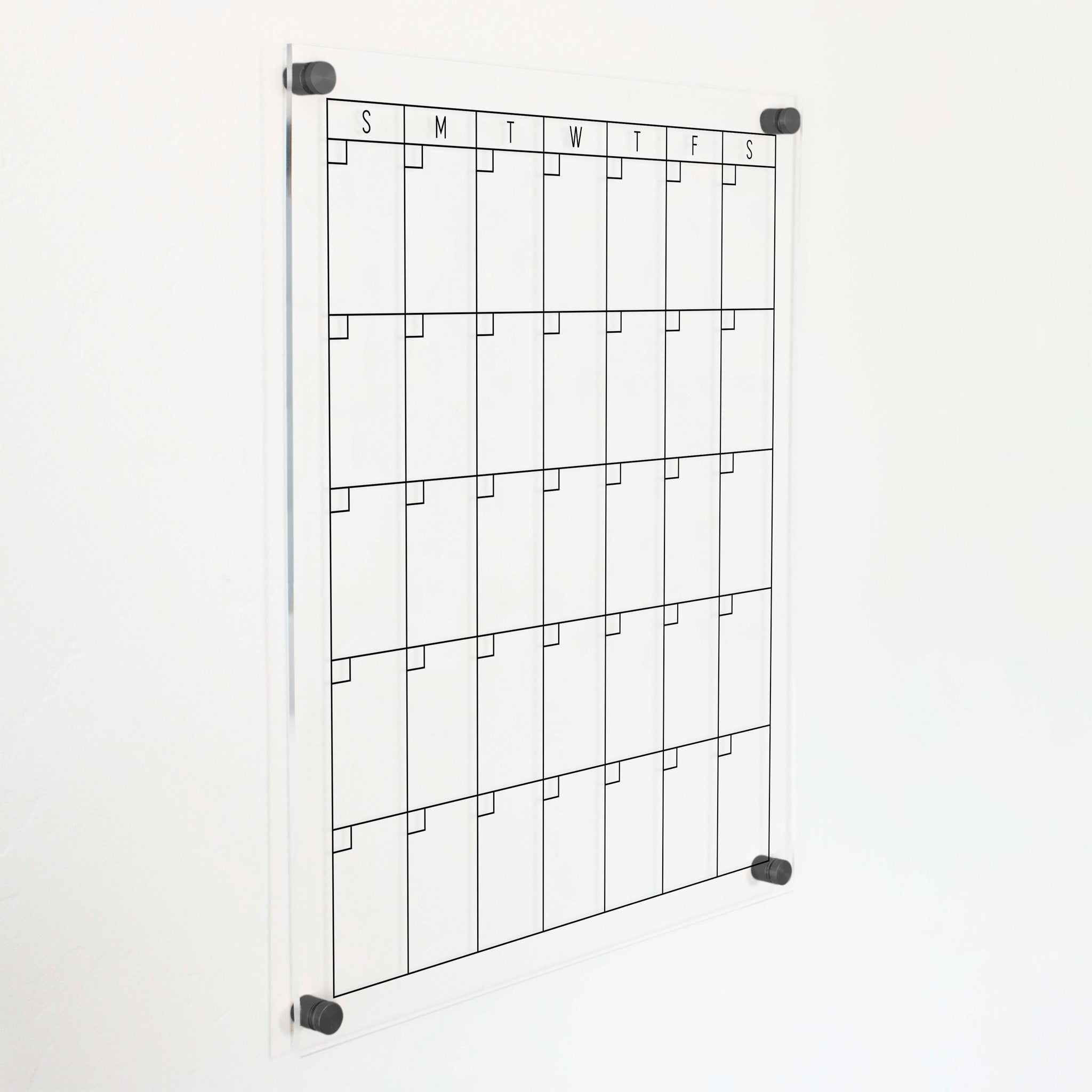 A Dry-erase monthly calender made of acrylic hanging on the wall