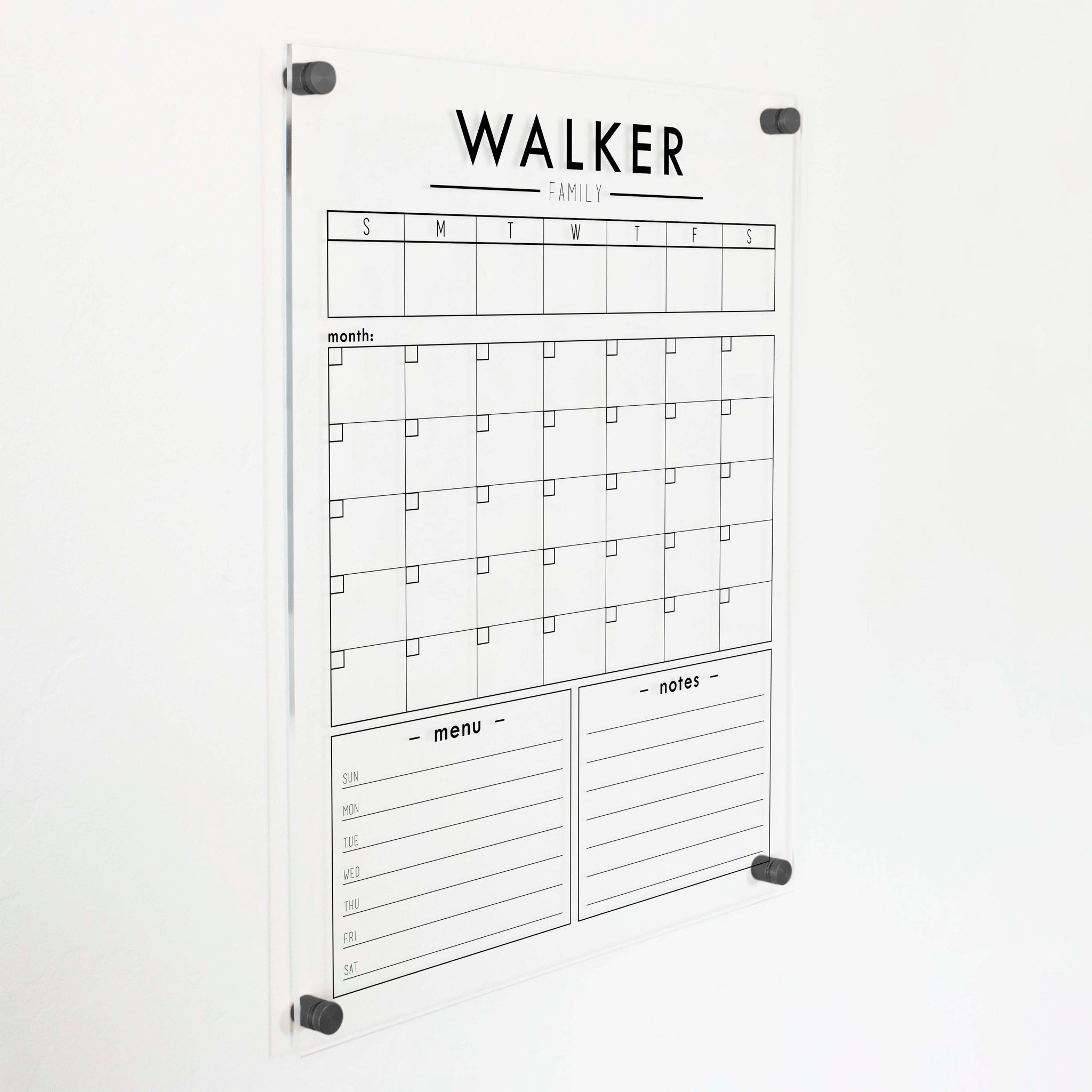 A Dry-erase calendar with a monthly and weekly format made of acrylic hanging on the wall