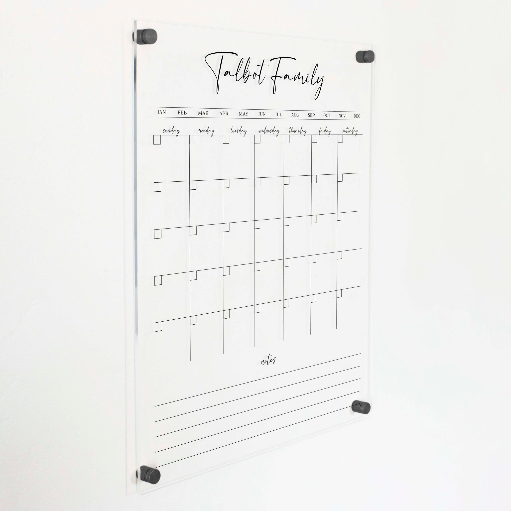 A Dry-erase monthly calender made of acrylic hanging on the wall