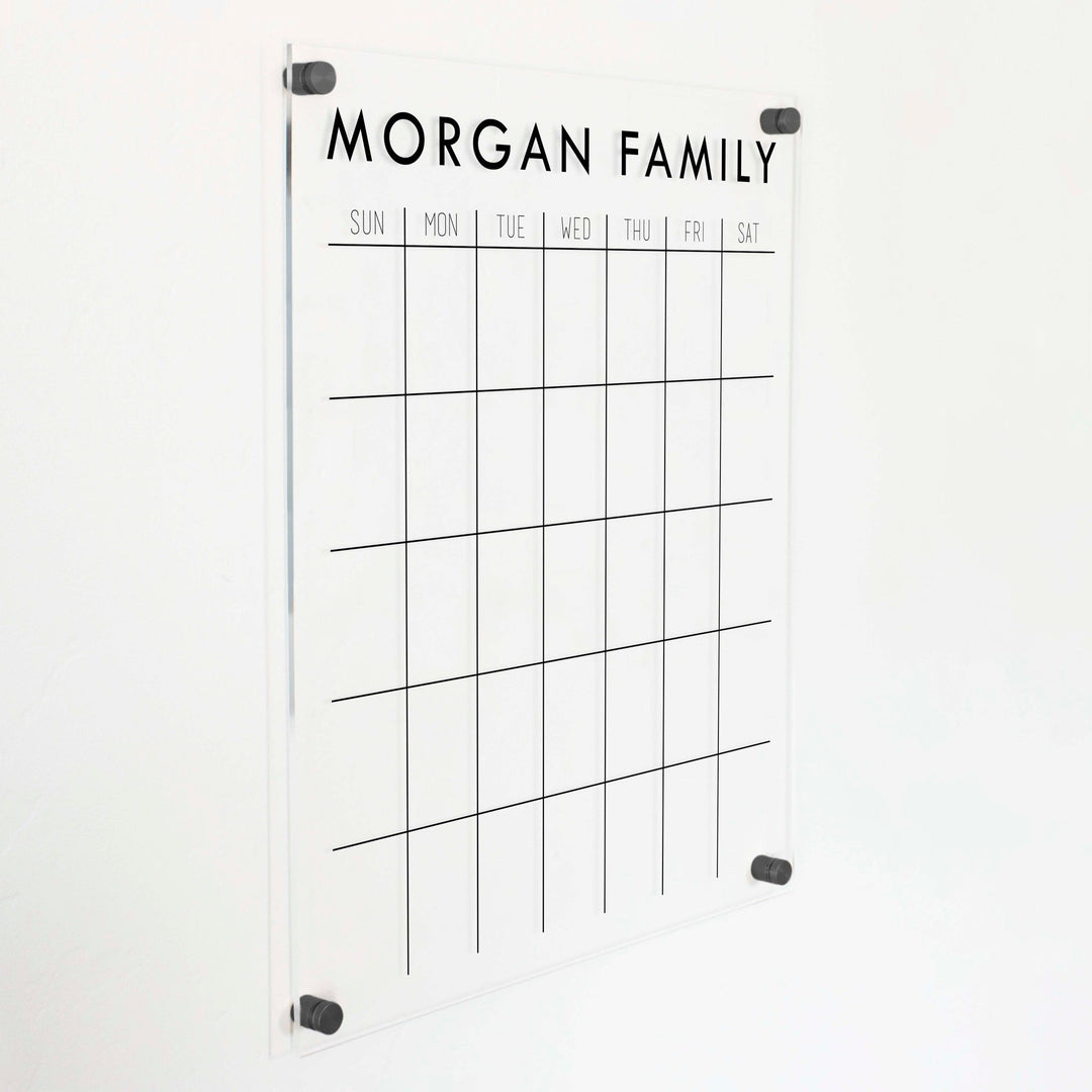 A Dry-erase monthly calender made of acrylic hanging on the wall