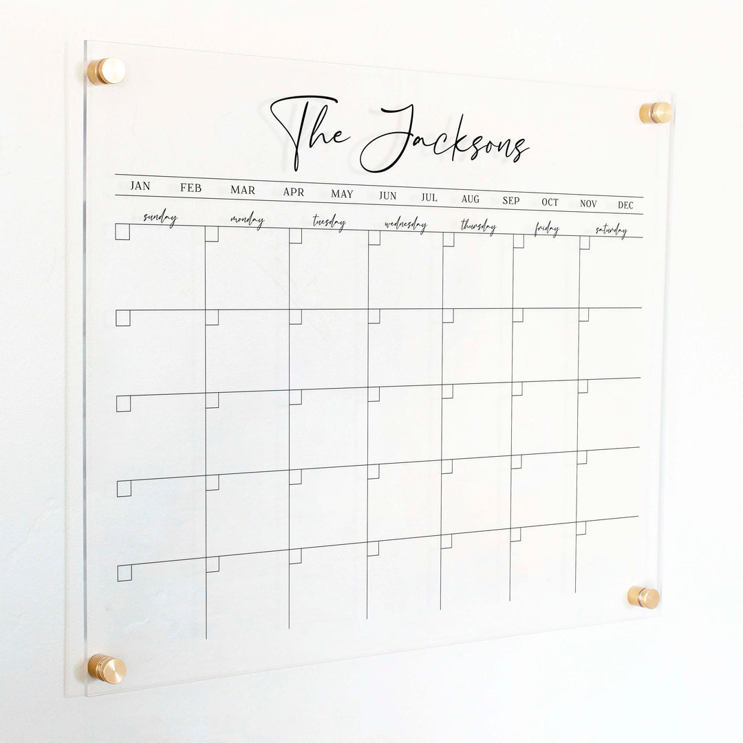 A Dry-erase monthly calender made of acrylic hanging on the wall