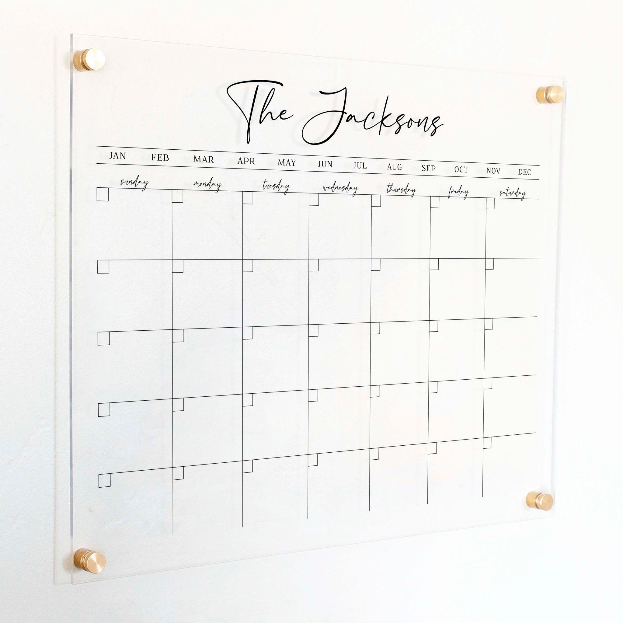 A Dry-erase monthly calender made of acrylic hanging on the wall