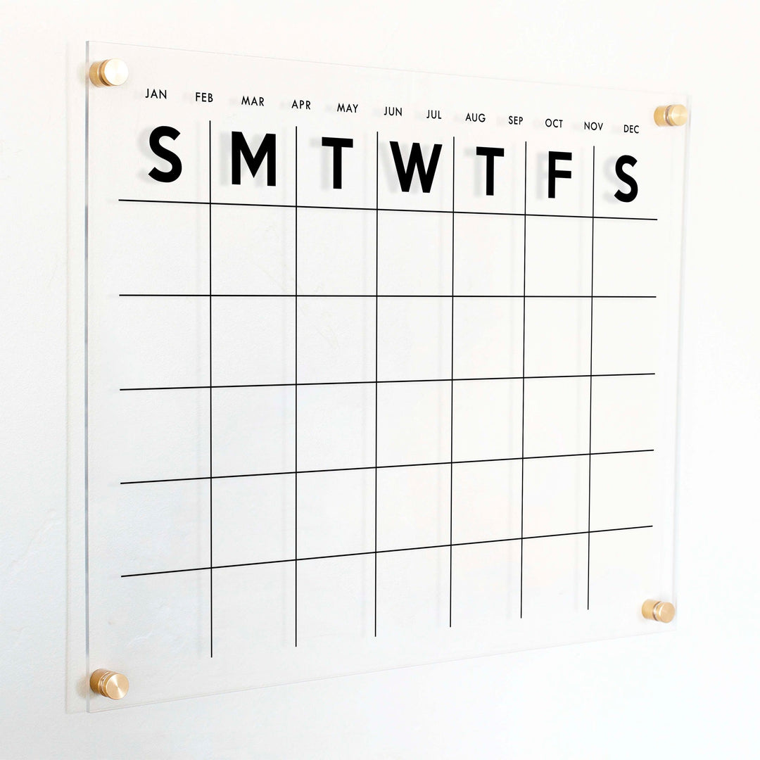 A Dry-erase monthly calender made of acrylic hanging on the wall