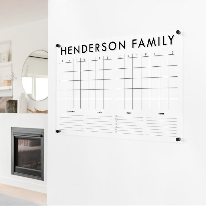 A Dry-erase acrylic calendar with a two month design format hanging on the wall