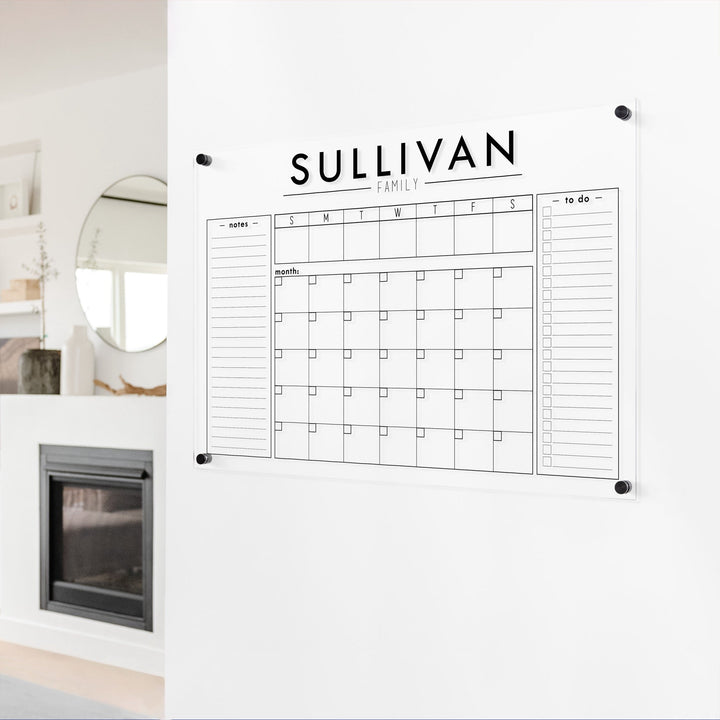 A Dry-erase calendar with a monthly and weekly format made of acrylic hanging on the wall