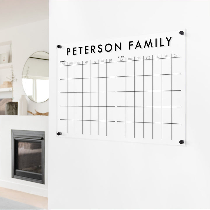 A Dry-erase acrylic calendar with a two month design format hanging on the wall
