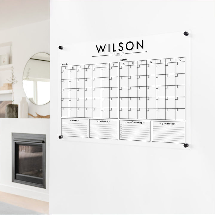 A Dry-erase acrylic calendar with a two month design format hanging on the wall