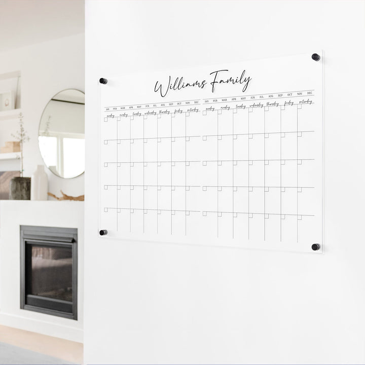 A Dry-erase acrylic calendar with a two month design format hanging on the wall