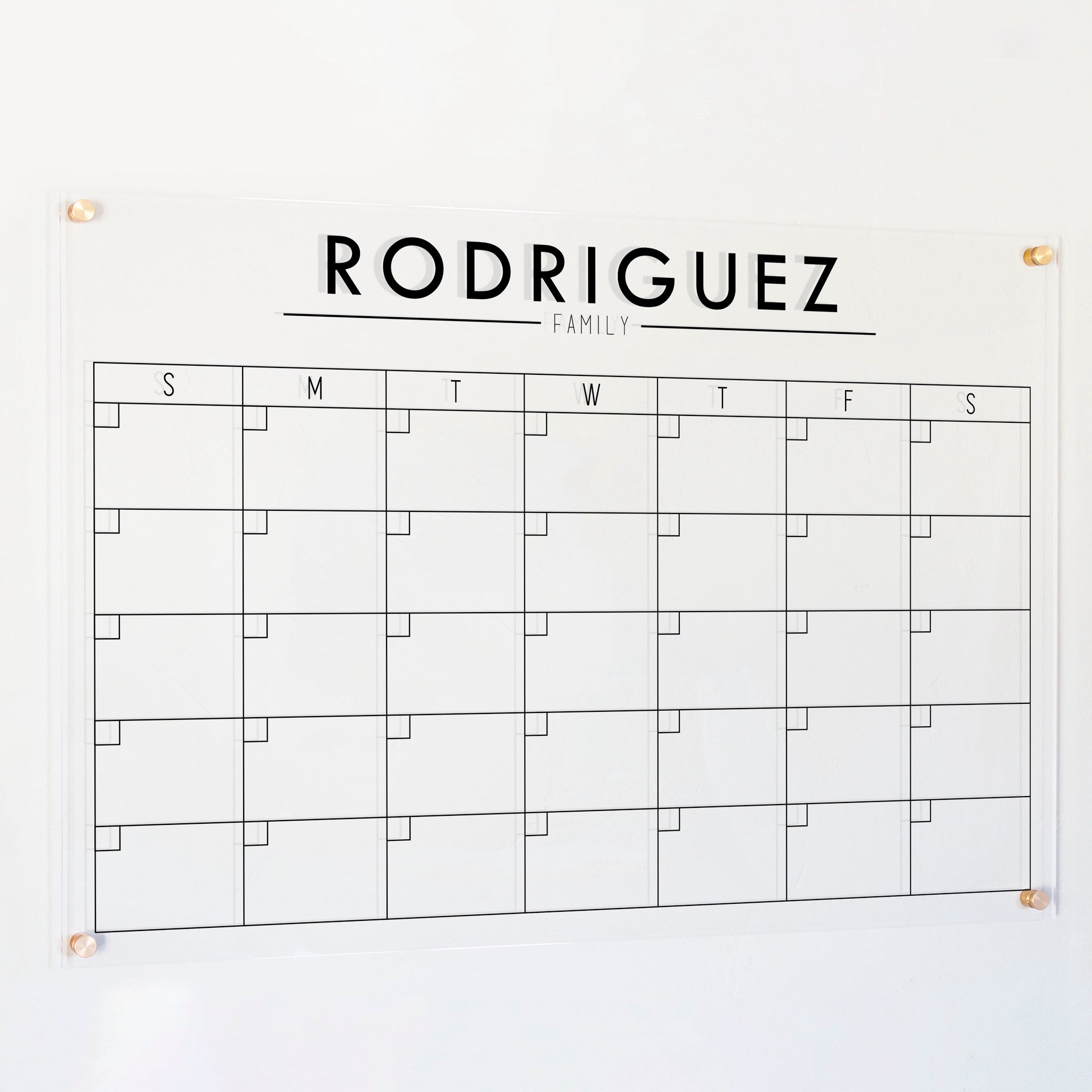 A Dry-erase monthly calender made of acrylic hanging on the wall