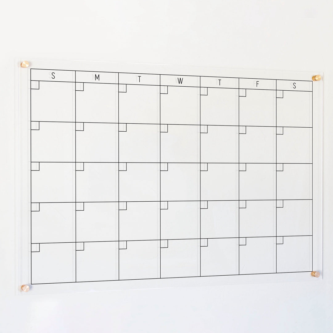 A Dry-erase monthly calender made of acrylic hanging on the wall