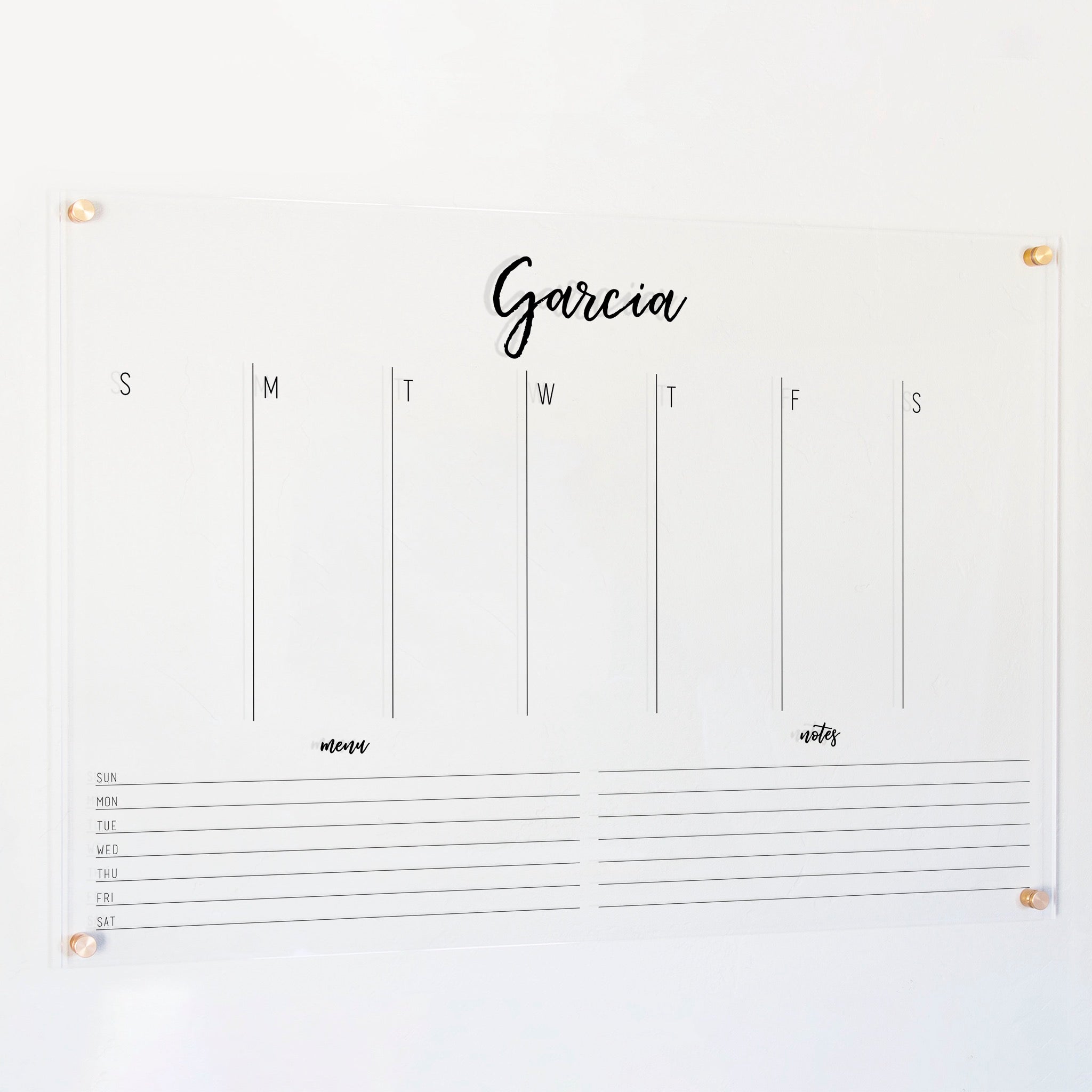 A Dry-erase weekly calender made of acrylic hanging on the wall