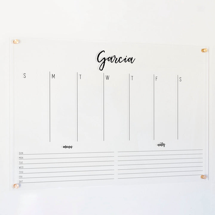 A Dry-erase weekly calender made of acrylic hanging on the wall
