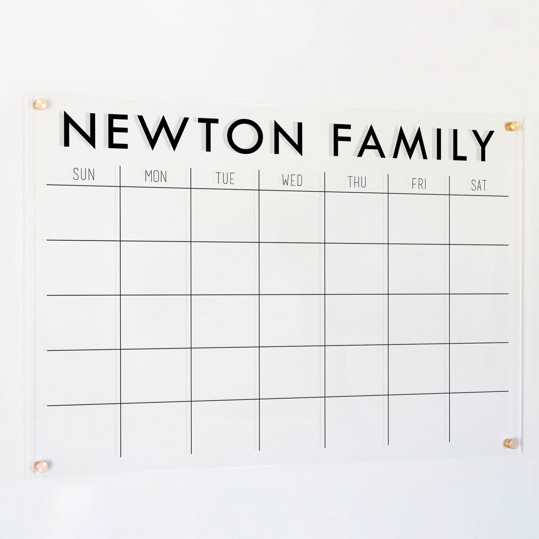 A Dry-erase monthly calender made of acrylic hanging on the wall