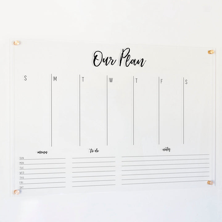 A Dry-erase weekly calender made of acrylic hanging on the wall