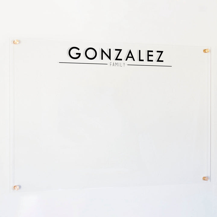 A dry-erase board made of clear acrylic with a custom title up top