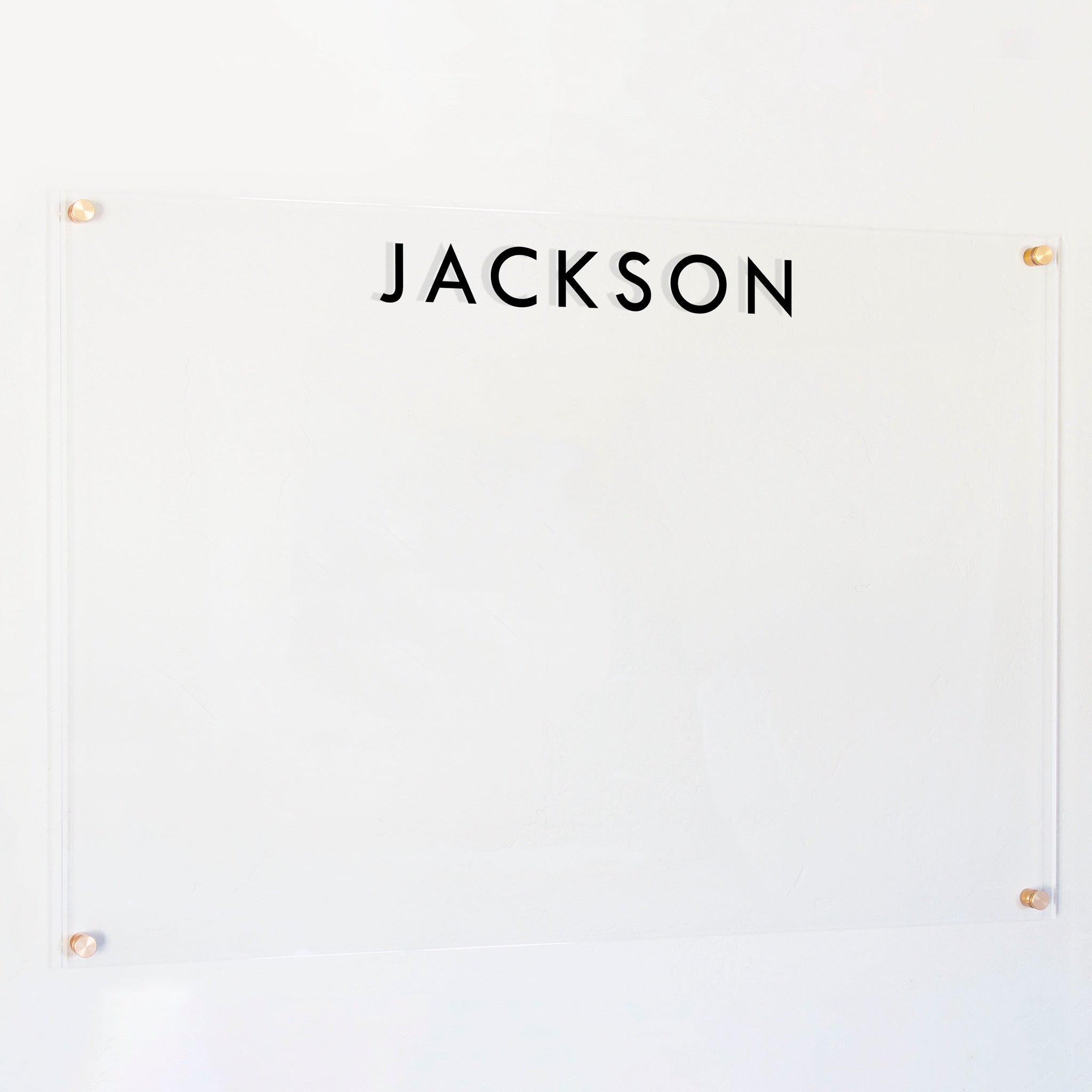 A dry-erase board made of clear acrylic with a custom title up top