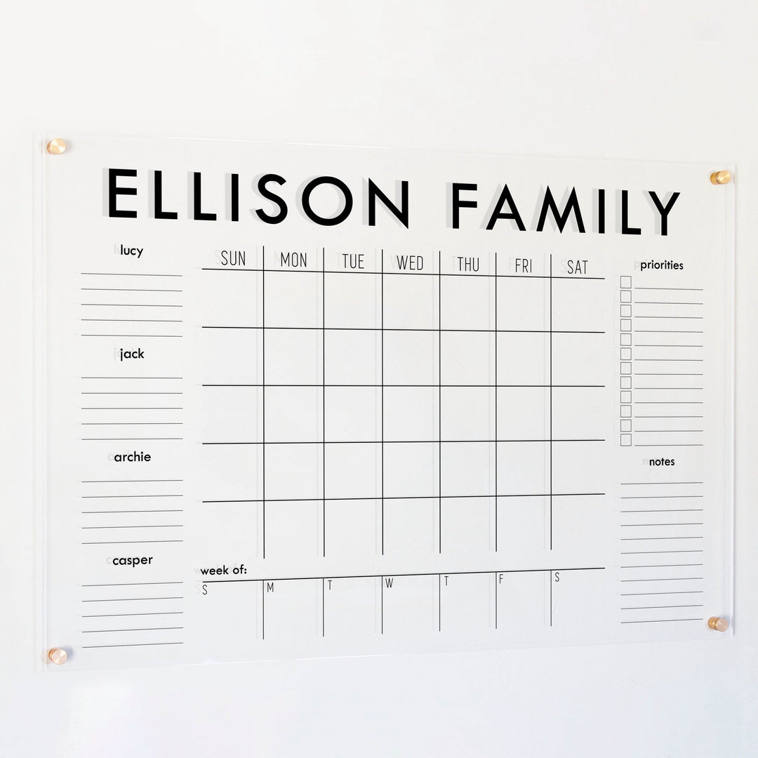 A Dry-erase calendar with a monthly and weekly format made of acrylic hanging on the wall