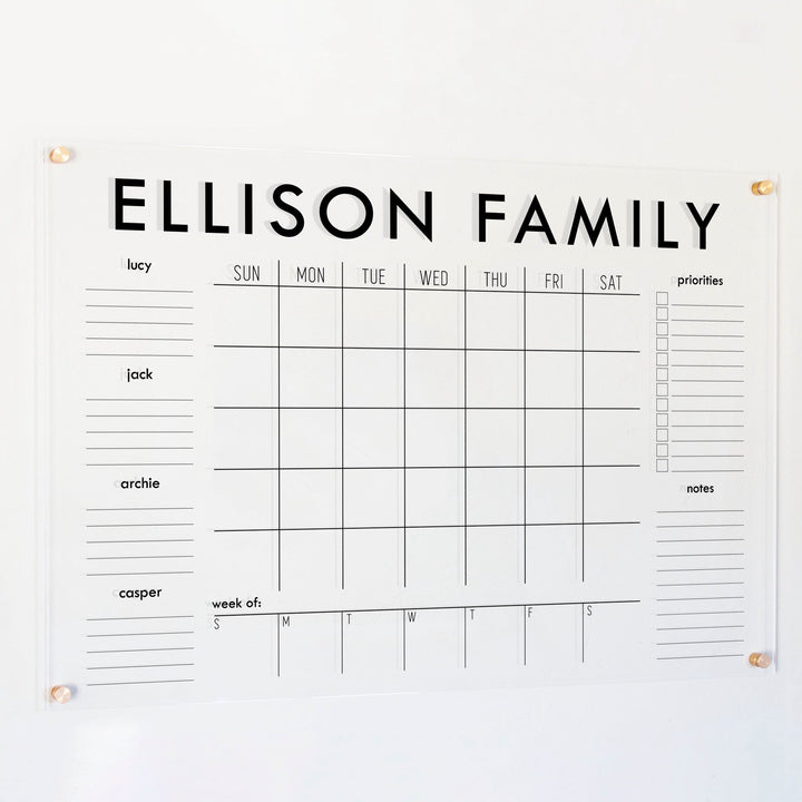 A Dry-erase calendar with a monthly and weekly format made of acrylic hanging on the wall