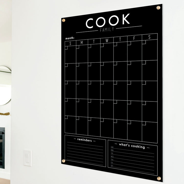 A Dry-erase monthly calender made of acrylic hanging on the wall