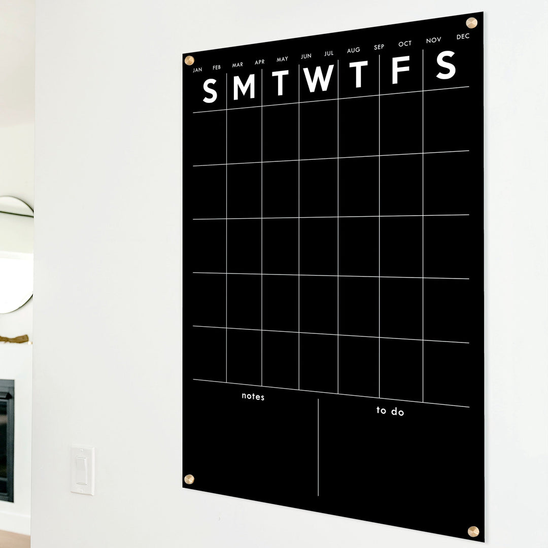 A Dry-erase monthly calender made of acrylic hanging on the wall