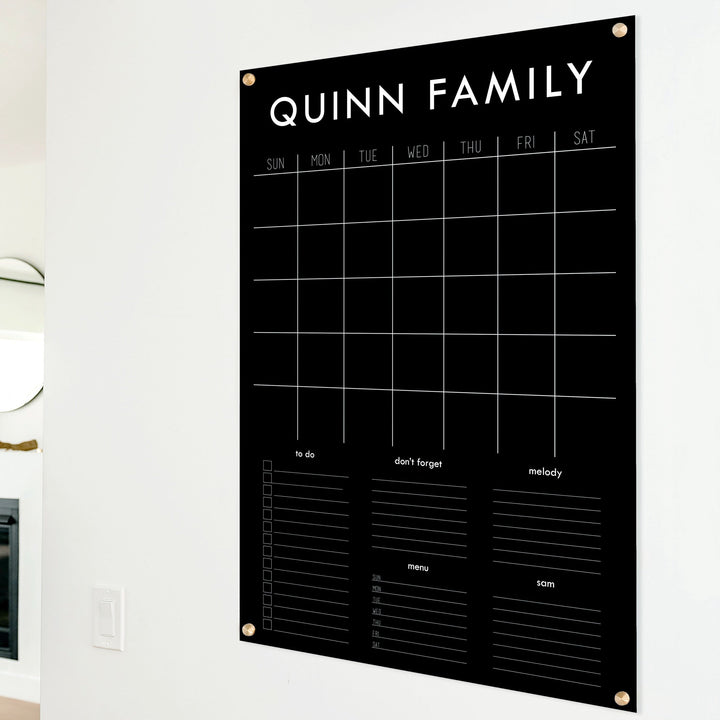 A Dry-erase family command center made of acrylic hanging on the wall