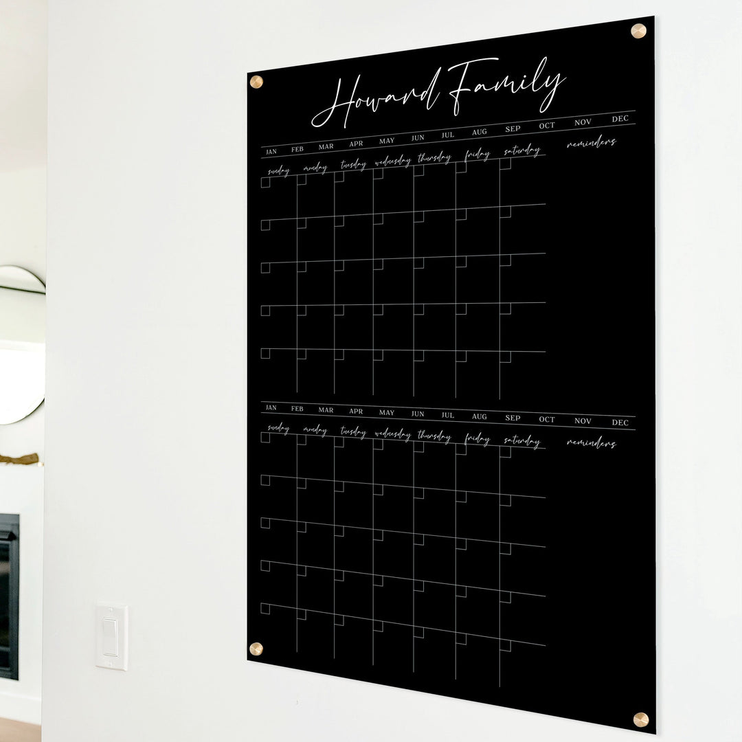 A Dry-erase acrylic calendar with a two month design format hanging on the wall