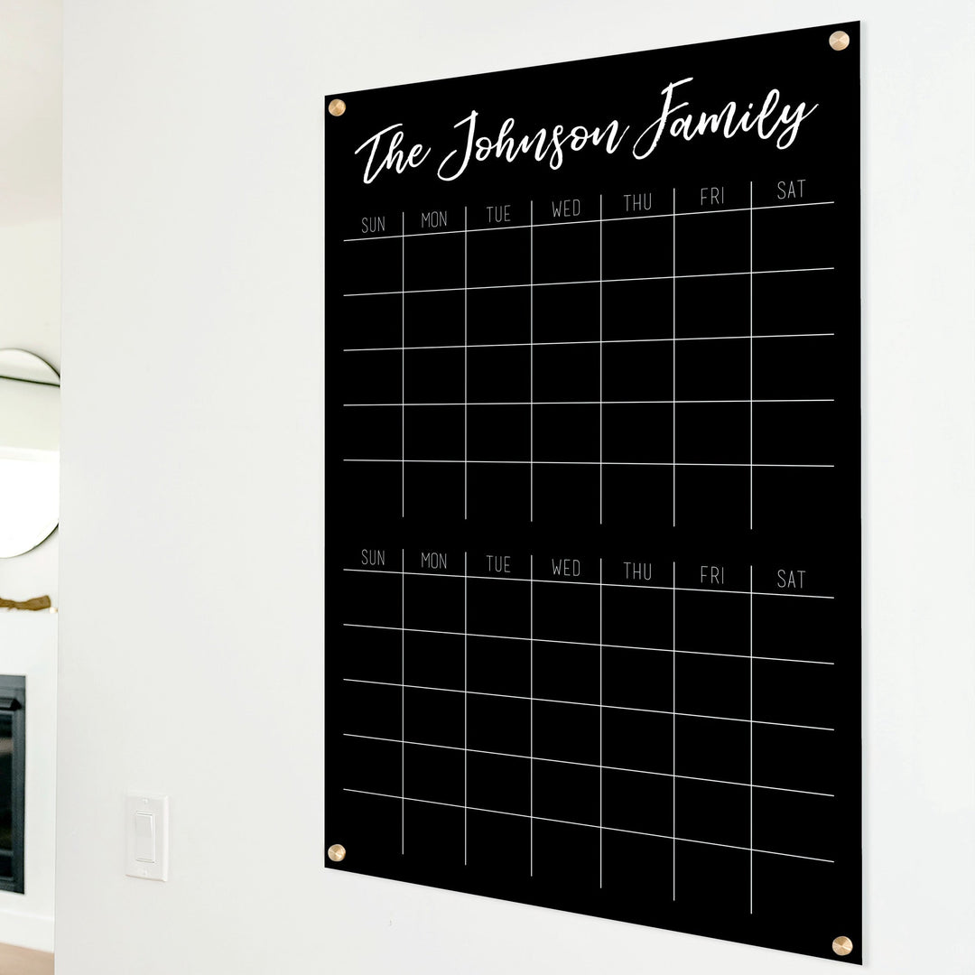 A Dry-erase acrylic calendar with a two month design format hanging on the wall