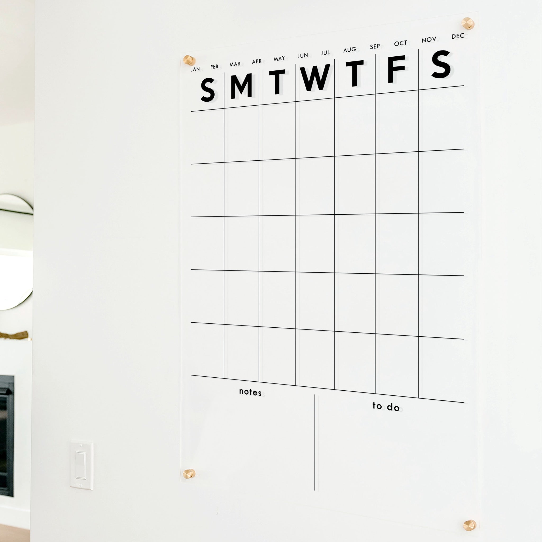 A Dry-erase monthly calender made of acrylic hanging on the wall