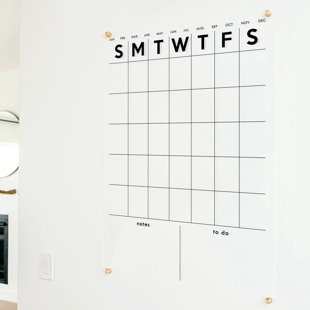 A Dry-erase monthly calender made of acrylic hanging on the wall
