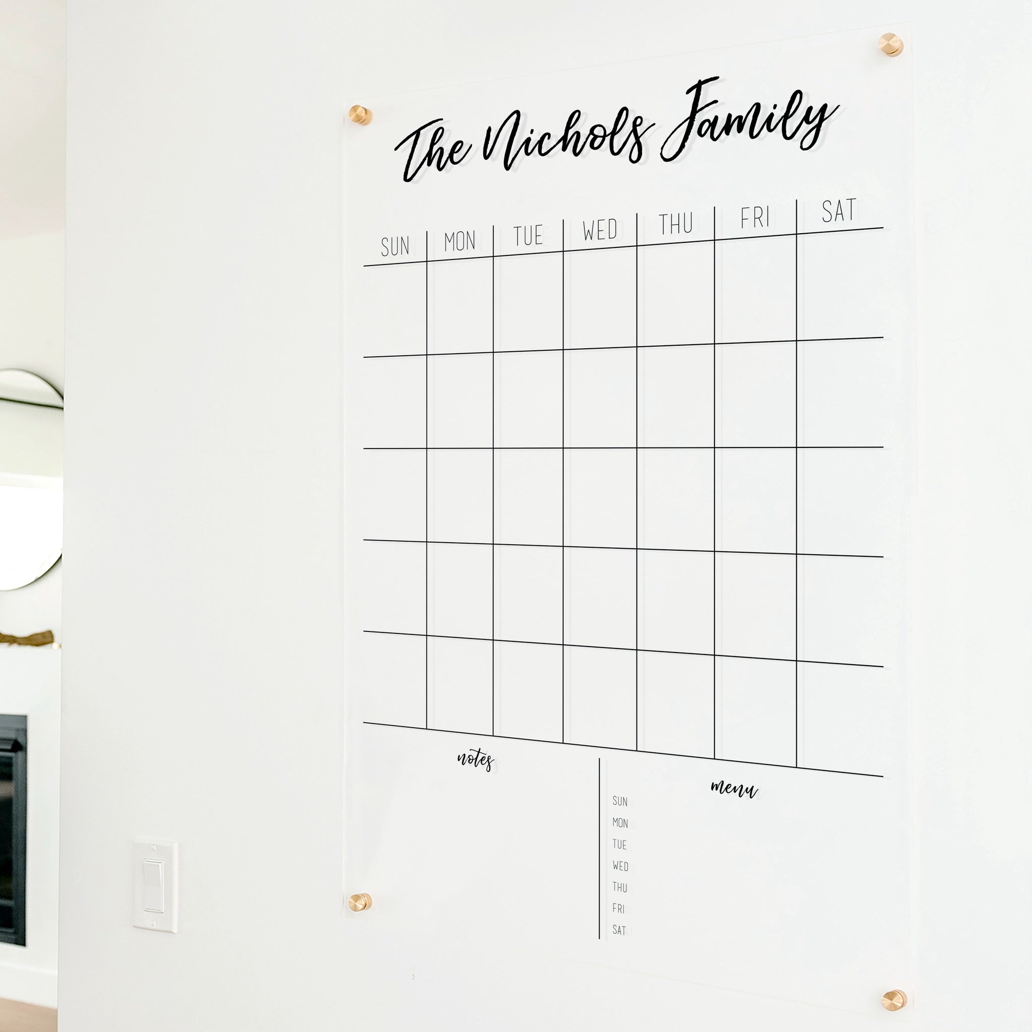 A Dry-erase monthly calender made of acrylic hanging on the wall