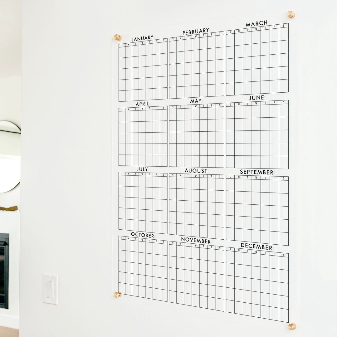 A dry-erase yearly calendar made of acrylic hanging up on the wall