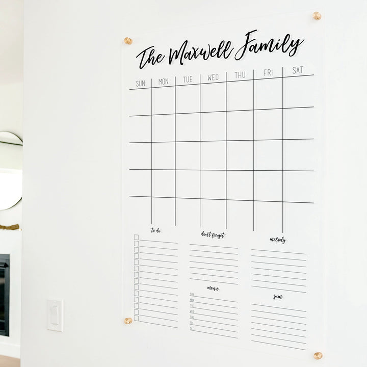 A Dry-erase family command center made of acrylic hanging on the wall
