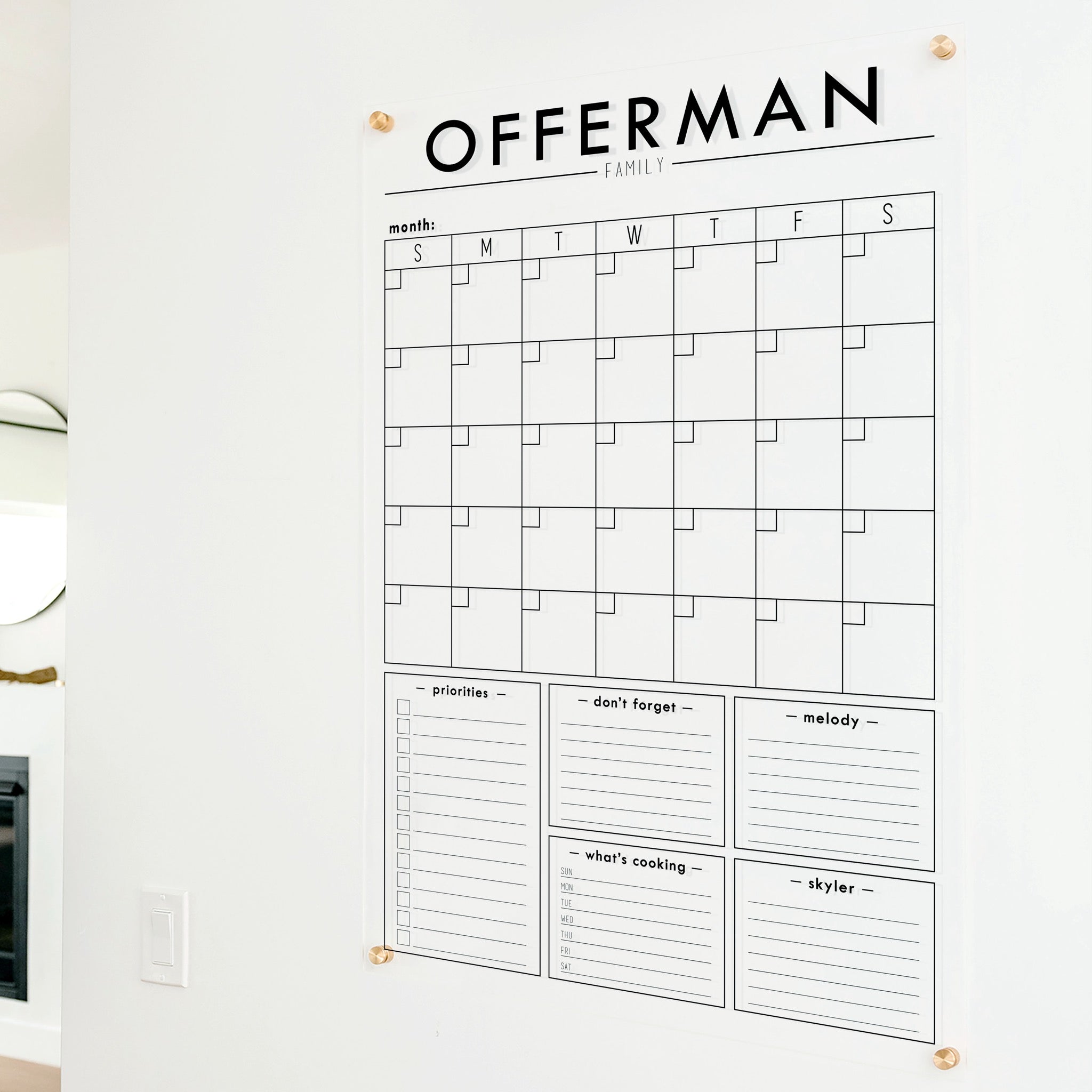 A Dry-erase family command center made of acrylic hanging on the wall