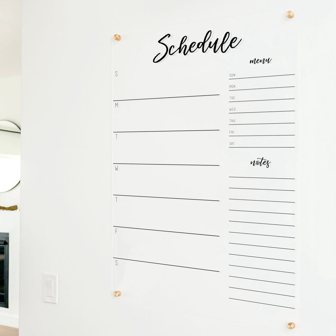 A Dry-erase weekly calender made of acrylic hanging on the wall