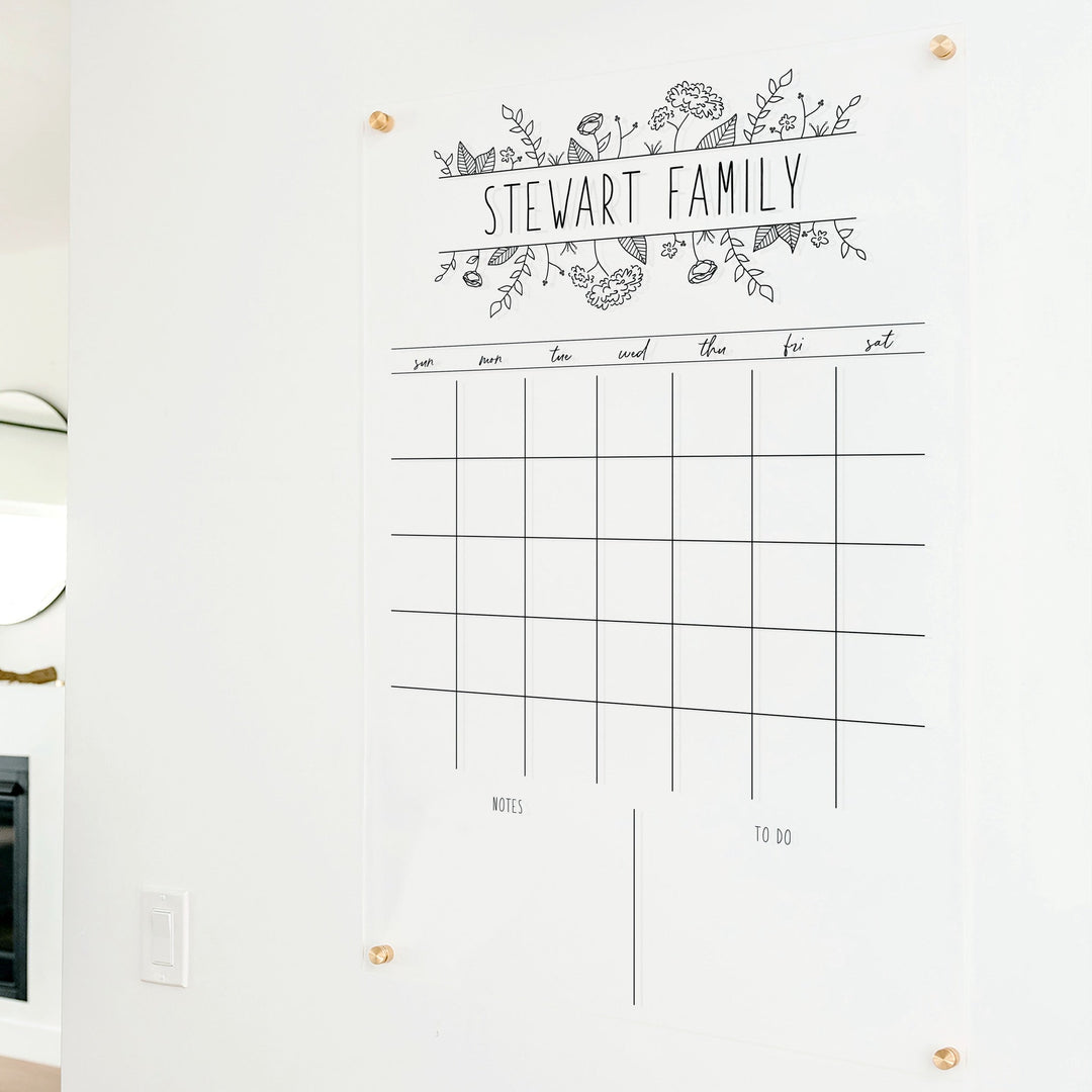 A Dry-erase monthly calender made of acrylic hanging on the wall